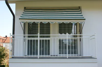 A close-up view of a striped awning over a balcony door.