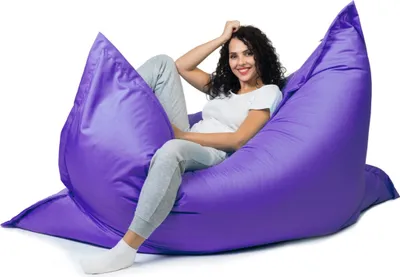 A woman sitting on a large purple beanbag chair.