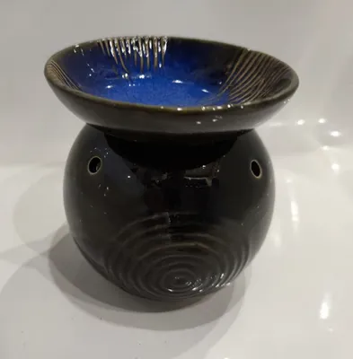 Eine blau/schwarze, runde Duftlampe mit abnehmbarer Schale und einem konzentrischem Kreis-Muster.