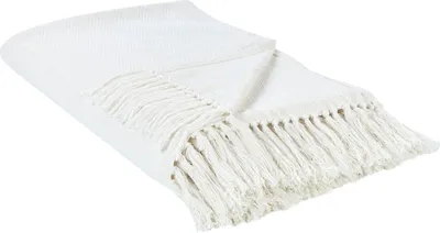 A white blanket with fringe is laid out on a white background.