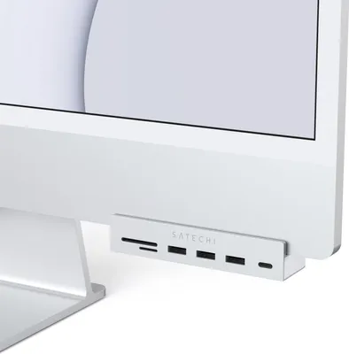 A close-up shot of a Satechi USB-C hub attached to the bottom of an iMac.