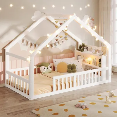 A child's bed in a room decorated with fairy lights and clouds.