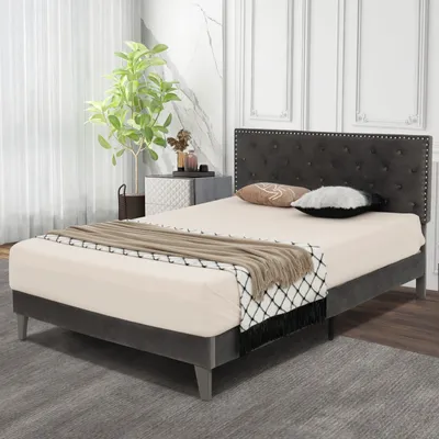 A bedroom scene with a bed, nightstand, and plant.