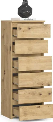 A tall, narrow chest of drawers with six drawers, made of light brown wood with visible grain. A black, geometric decorative object sits on top of the chest, along with a book.