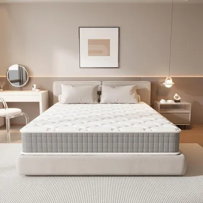 A bedroom scene featuring a mattress on a bed frame, with a nightstand and vanity table in the background.