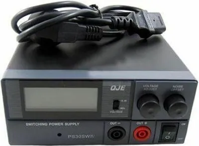 A close-up, slightly angled view of a black switching power supply unit with a digital display and various controls.