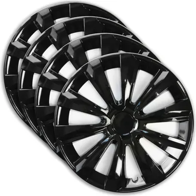 A set of four black wheel covers are stacked and angled on a white background.