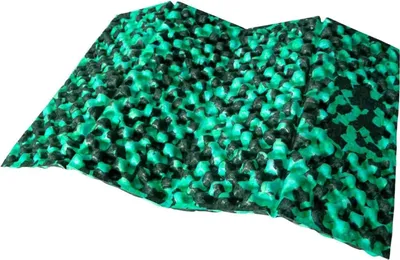 A textured cushion with a repeating pattern of green and black elements, shown from a slightly elevated angle.