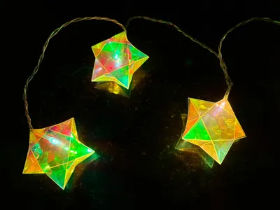 Three star-shaped LED lights on a dark, reflective surface.
