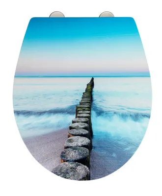 A toilet seat with a printed image of a wooden breakwater on a beach at sunset.