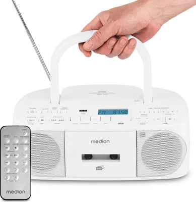 A hand holds the handle of a white Medion radiorecorder with a remote control in the foreground.