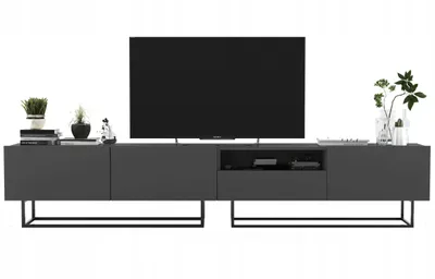 A modern, dark gray TV stand with a television and decorative items on a white background.