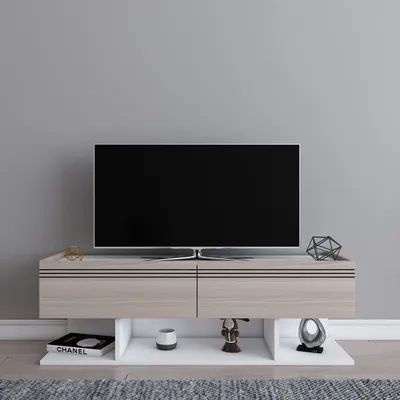 A modern TV stand with a TV and decorative items in a room.