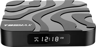 A close-up studio shot of a black smart TV box with a patterned top and a digital display on the front.