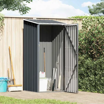 A garden shed with tools and a bucket next to it, set against a wooden fence and greenery.