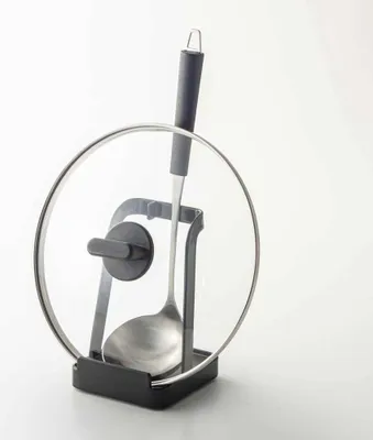 A ladle and pot lid holder on a white background.