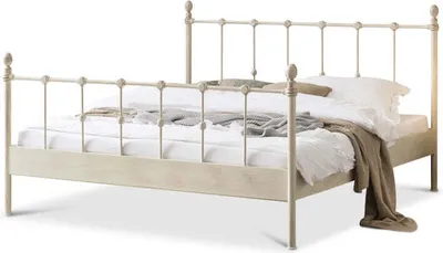 A metal bed frame with bedding and a throw blanket.