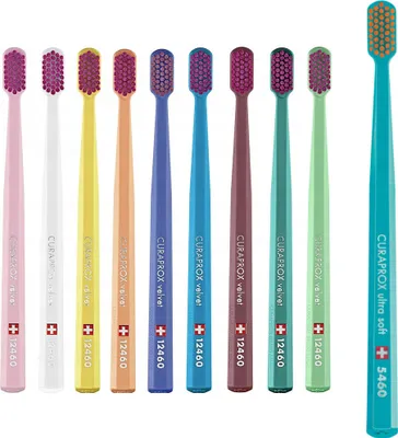 A collection of colorful toothbrushes arranged in a row against a white background.
