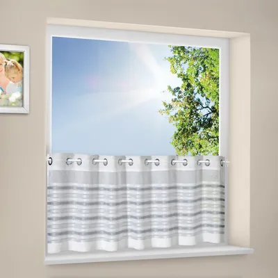 A window with a curtain and a framed picture on the wall.