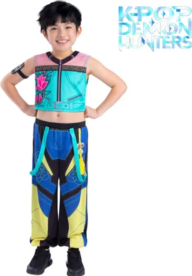 Kind trägt ein KPop Demon Hunters Kinderkostüm mit türkisfarbenem Crop-Top, bedruckter Hose in Blau-Gelb und schwarzen Sneakers. Das Kind steht frontal mit Händen in die Hüften gestützt vor weißem Hintergrund mit Serienlogo.