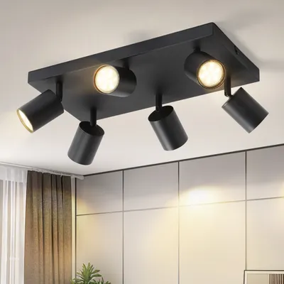 A black ceiling light fixture with multiple adjustable spotlights is mounted on a white ceiling.