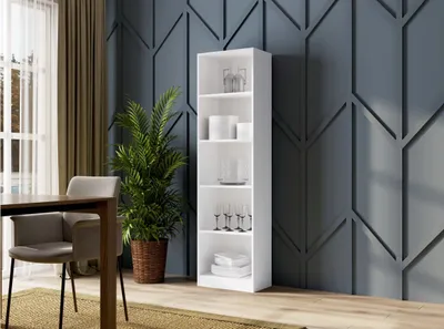 A white bookshelf filled with dishes and glasses, placed in a room with a decorative blue wall and a dining table with chairs.