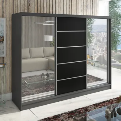 A large, modern sliding door wardrobe with mirrored panels and black sections, reflecting a living room interior and a city view from a balcony.