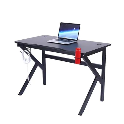 A black gaming desk with a laptop, headphones, and a red cup holder.