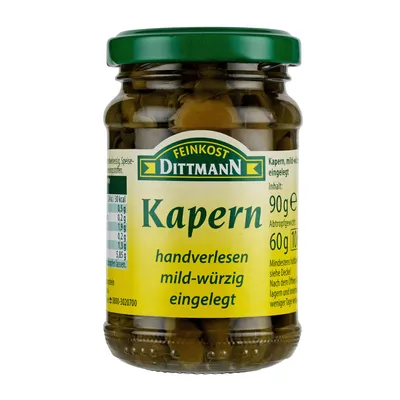 A jar of capers on a white background.