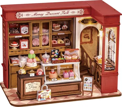 A miniature dollhouse dessert shop with detailed miniature food items and furniture.