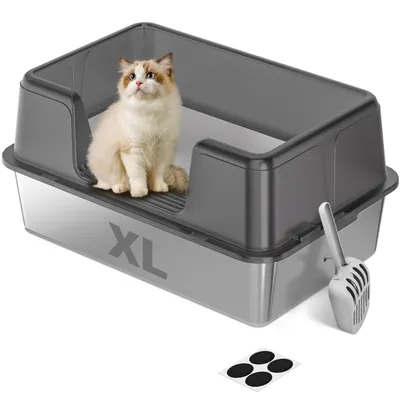 A cat sits in a large, semi-enclosed litter box with a scoop and anti-slip pads nearby.