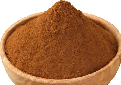 A wooden bowl filled with ground cinnamon.