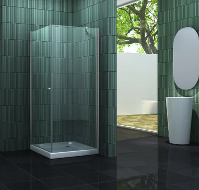 A modern bathroom with a glass shower enclosure, green tiled walls, and black tiled floor.