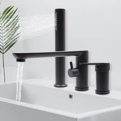 A black bathtub faucet with a handheld showerhead is shown installed on a white sink. Water is running from the faucet.