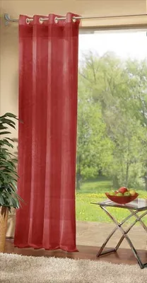 A red curtain is shown hanging in front of a window with a view of trees and a small table with fruit.