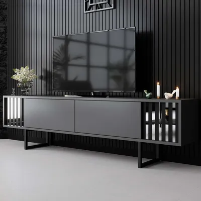 A modern TV stand with a television on top, set against a dark, slatted wall.