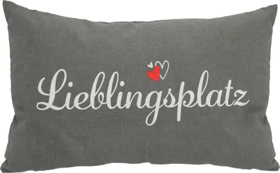 A rectangular pillow with text and hearts printed on it.