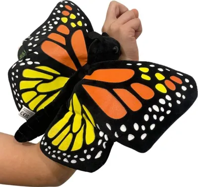 A plush butterfly toy is worn on a person's arm.