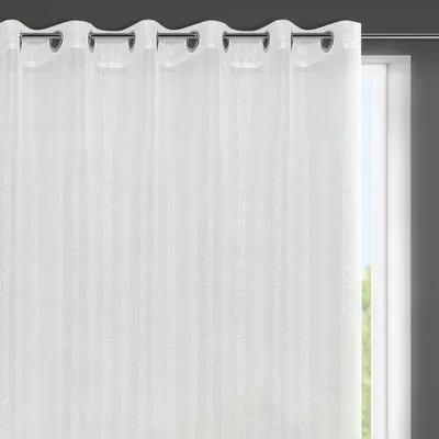 A close-up of a white curtain with grommets, hanging in front of a window.