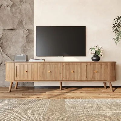 A TV stand with a TV and decor in a living room setting.
