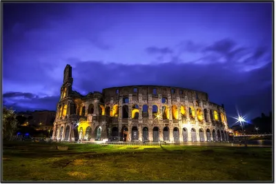 Produktbild von Wallario Wandbild Italien bei Nacht - Kollosseum in Rom, beleuchtet am Abend, Größe: 61 x 91,50 cm, Poster mit schwarzem Aluminiumrahmen