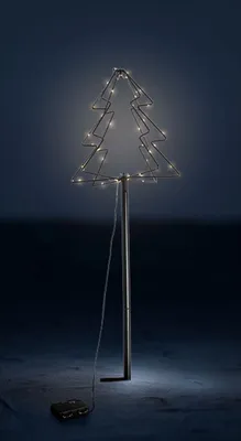 A lit-up Christmas tree decoration on a pole, with a wire and a battery pack on the ground.
