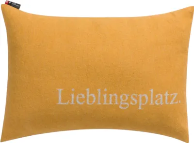 A yellow pillow with text on it.