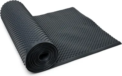 A rolled-up black drainage mat with a dimpled texture is laid out on a white surface.