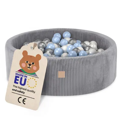 A grey corduroy ball pit filled with blue, white, and silver balls, with a tag attached to the side.