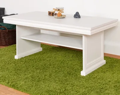 A white coffee table with a shelf underneath, placed on a green shag carpet.