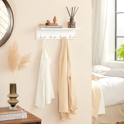 A wall-mounted shelf with hooks in a bedroom setting.