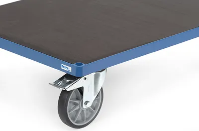 A close-up of a corner of a flatbed trolley, showing a wheel and the edge of the platform.