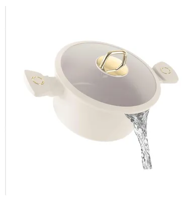 A cream-colored pot with a glass lid and gold accents, with water pouring out of it.