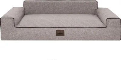 A dog bed with raised sides and a small brown logo tag on the front.
